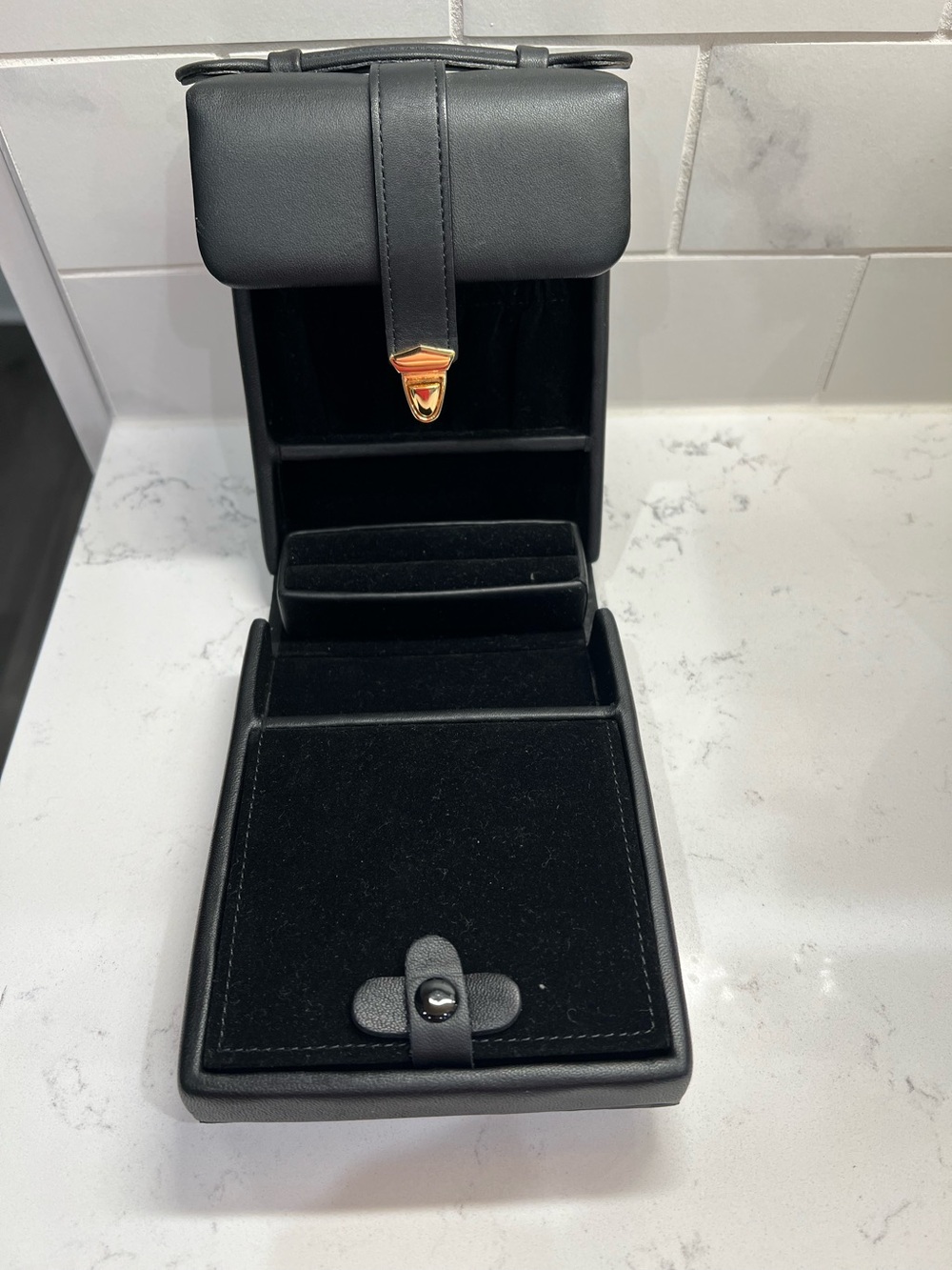 Black travel jewelry case w/ a gold-tone clasp & velvet interior.